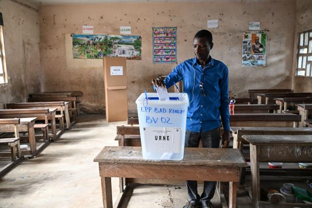 A voter casts his ballot at the Kenedy school group polling station in Cocody, Abidjan, on October 25, 2025 during Ivory Coast's presidential elections. (Photo by SIA KAMBOU / AFP)