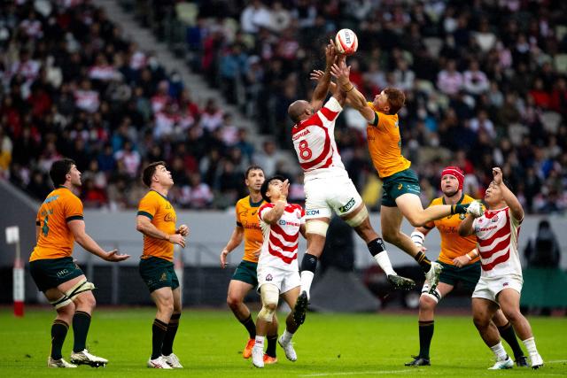 Japan's Michael Leitch (top L) and Australia's Tane Edmed compete for the ball during the international rugby union Test match between Japan and Australia at the National Stadium in Tokyo on October 25, 2025. (Photo by Philip FONG / AFP)