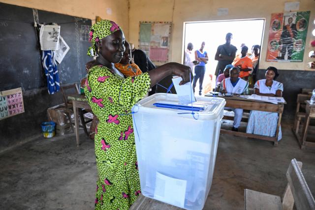 A voter casts her ballot at a polling station in Agboville on October 25, 2025 during Ivory Coast's presidential elections. (Photo by Issouf SANOGO / AFP)