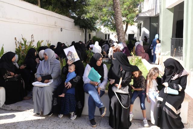 Syrian nationals wait at a service office affiliated with the Syrian Embassy in Tripoli after the Syrian Foreign Ministry announced that it will grant free return tickets to its citizens wishing to leave Libya, on October 25, 2025.  (Photo by Mahmud Turkia / AFP)