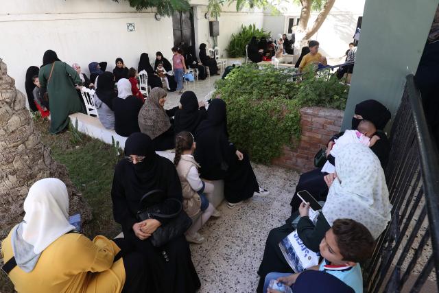 Syrian nationals wait at a service office affiliated with the Syrian Embassy in Tripoli after the Syrian Foreign Ministry announced that it will grant free return tickets to its citizens wishing to leave Libya, on October 25, 2025.  (Photo by Mahmud Turkia / AFP)