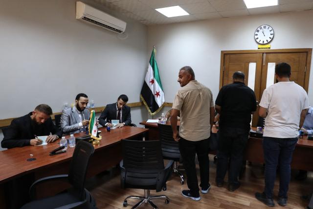 Syrian nationals register at a service office affiliated with the Syrian Embassy in Tripoli after the Syrian Foreign Ministry announced that it will grant free return tickets to its citizens wishing to leave Libya, on October 25, 2025.  (Photo by Mahmud Turkia / AFP)