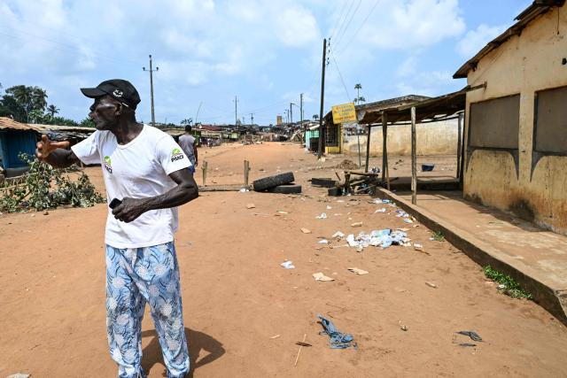 A resident gestures in a road near a barricade in Lopou, near Dabou, on October 25, 2025 where villagers disrupted the presidential vote. In Lopou, located about 40 kilometers west of Abidjan, both the main roads and the small adjacent tracks were blocked by protesters on October 25, 2025, an AFP team observed.
Between anger and disillusionment, this town illustrates the tension prevailing in certain areas of southern Ivory Coast on this presidential election day.
Supporters of former President Laurent Gbagbo and Tidjane Thiam, both excluded from the ballot, are attempting to disrupt the vote, in which incumbent President Alassane Ouattara is the clear favorite. (Photo by Issouf SANOGO / AFP)