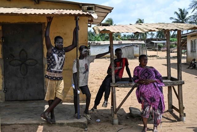 TOPSHOT - Residents stand next to closed stalls in Lopou, near Dabou, on October 25, 2025 where villagers disrupted the presidential vote. In Lopou, located about 40 kilometers west of Abidjan, both the main roads and the small adjacent tracks were blocked by protesters on October 25, 2025, an AFP team observed.
Between anger and disillusionment, this town illustrates the tension prevailing in certain areas of southern Ivory Coast on this presidential election day.
Supporters of former President Laurent Gbagbo and Tidjane Thiam, both excluded from the ballot, are attempting to disrupt the vote, in which incumbent President Alassane Ouattara is the clear favorite. (Photo by Issouf SANOGO / AFP)