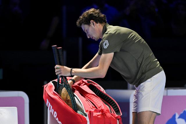 France's Ugo Humbert packs up his rackets before leaving the court after he withdrew from the match due to injury during his men's semi final match against Spain's Alejandro Davidovich Fokina at the Swiss Indoors ATP 500 tennis tournament in Basel, on October 25, 2025. (Photo by Fabrice COFFRINI / AFP)