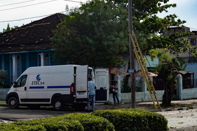 An employee of the Cuban Telecommunications Company (ETECSA) works on a street ahead of the arrival of Tropical Storm Melissa in Santiago de Cuba on October 25, 2025. Cuba has begun preparations to face the impact of Tropical Storm Melissa in at least two provinces in the central and eastern parts of the island, as the storm moves toward Jamaica. (Photo by AFP)