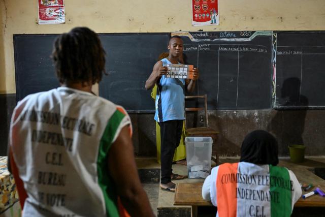 Independent Electoral Commission of Ivory Coast (CEI) officials count votes at a polling station in Dabou on October 25, 2025 after polls closed during Ivory Coast's presidential elections. (Photo by Issouf SANOGO / AFP)