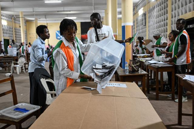 An Independent Electoral Commission of Ivory Coast (CEI) official empties a ballot box as they count votes at the Notre-Dame College, in Plateau, the business district of Abidjan, on October 25, 2025 after polls closed during Ivory Coast's presidential elections. (Photo by Sia KAMBOU / AFP)