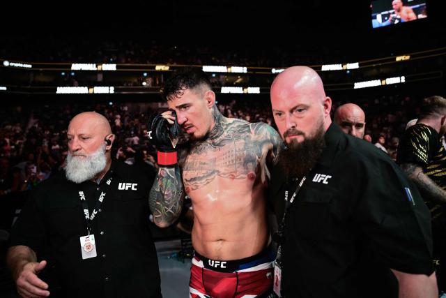 Britain’s Tom Aspinall leaves the ring after being hit in the eye while fighting France’s Ciryl Gane during their UFC heavyweight title bout at UFC 321 at Etihad Arena in Abu Dhabi early on October 26, 2025. (Photo by Giuseppe CACACE / AFP)