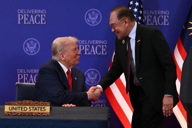US President Donald Trump (L) shakes hands with Malaysia's Prime Minister Anwar Ibrahim ahead of the ceremonial signing of a ceasefire agreement between Thailand and Cambodia on the sidelines of the 47th Association of Southeast Asian Nations (ASEAN) Summit in Kuala Lumpur on October 26, 2025. (Photo by ANDREW CABALLERO-REYNOLDS / AFP)