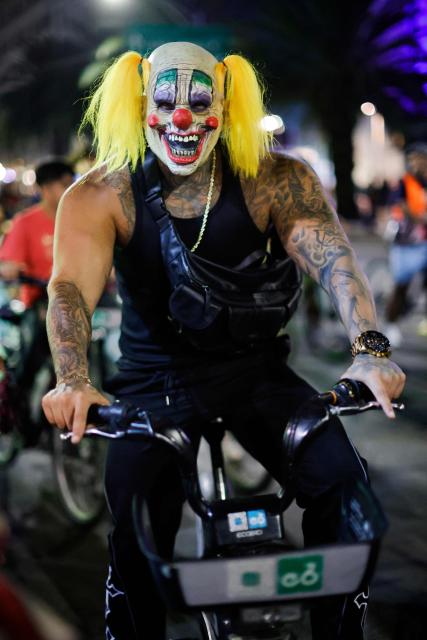 A cyclist in a mask participates in a nighttime ride ahead of the Day of the Dead ("Dia de los Muertos") celebrations in Mexico City on October 25, 2025. (Photo by Rodrigo Oropeza / AFP)