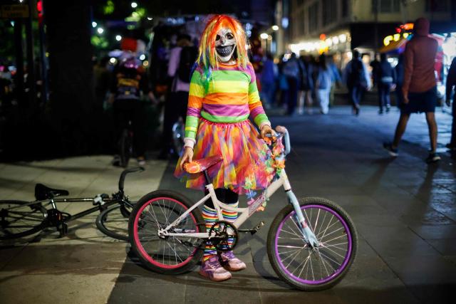 A cyclist in acostume poses as they participate in a nighttime ride ahead of the Day of the Dead ("Dia de los Muertos") celebrations in Mexico City on October 25, 2025. (Photo by Rodrigo Oropeza / AFP)