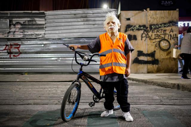 A cyclist in a mask poses during a nighttime ride ahead of the Day of the Dead ("Dia de los Muertos") celebrations in Mexico City on October 25, 2025. (Photo by Rodrigo Oropeza / AFP)