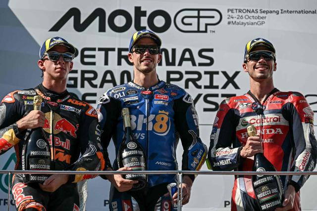 BK8 Gresini Racing MotoGP team's Spanish MotoGP rider Alex Marquez (C) celebrates on the podium after winning the MotoGP Malaysian Grand Prix with second-placed Red Bull KTM Factory Racing team's Spanish MotoGP rider Pedro Acosta (L) and third-placed Honda HRC Castrol team's Spanish MotoGP rider Joan Mir (R) at the Sepang International Circuit in Sepang on October 26, 2025. (Photo by Lillian SUWANRUMPHA / AFP)