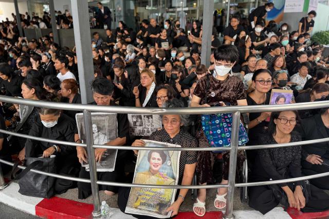 Mourners, some holding portraits of Thailand's former queen Sirikit, wait at Chulalongkorn Hospital for her body to be transported to the Grand Palace in Bangkok on October 26, 2025. The year-long funeral ceremony of Thailand's former Queen Sirikit started on October 26, with grieving royalists set to salute the procession bringing her remains to lie in state at Bangkok's Grand Palace. (Photo by Watsamon TRI-YASAKDA / AFP)
