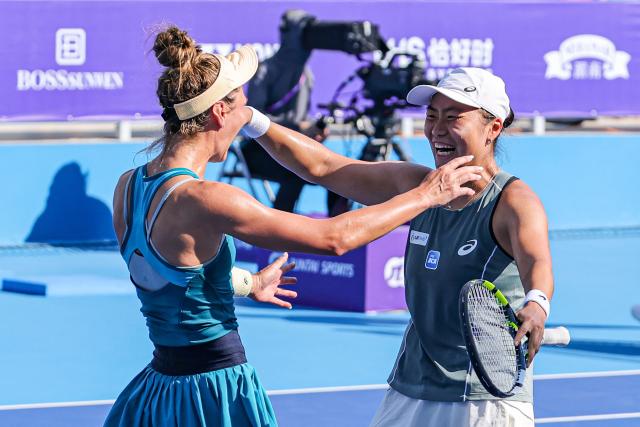 Indonesia's Janice Tjen (R) and Poland's Katarzyna Piter (L) celebrate after winning against Hong Kong's Eudice Chong and Taiwan's Liang En-shuo during their women's doubles at the Guangzhou Open tennis tournament in Guangzhou, southern China's Guangdong province on October 26, 2025. (Photo by AFP) / China OUT