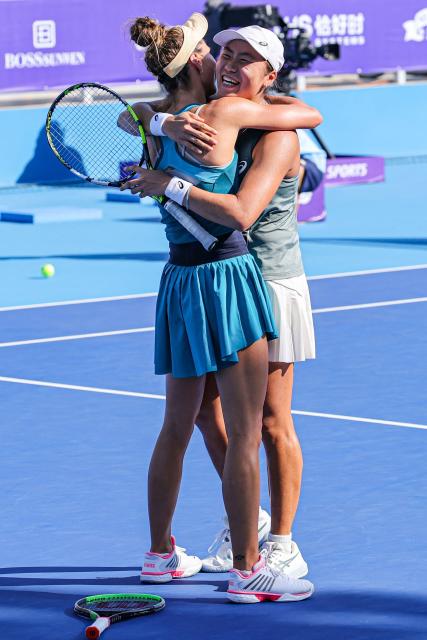 Indonesia's Janice Tjen (R) and Poland's Katarzyna Piter (L) celebrate after winning against Hong Kong's Eudice Chong and Taiwan's Liang En-shuo during their women's doubles at the Guangzhou Open tennis tournament in Guangzhou, southern China's Guangdong province on October 26, 2025. (Photo by AFP) / China OUT