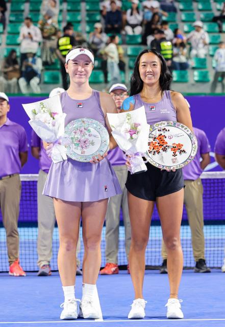 Winner USA's Ann Li (R) and runner up New Zealand's Lulu Sun pose with their trophies during an award ceremony following their women's singles final match at the Guangzhou Open tennis tournament in Guangzhou, southern China's Guangdong province on October 26, 2025. (Photo by AFP) / China OUT