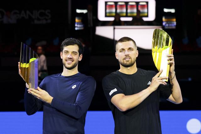 Winners Britain's Julian Cash and Lloyd Glasspool pose with their trophy's after the men's final doubles match at the ATP Vienna Open tennis tournament in Vienna, Austria, on October 26, 2025. (Photo by TOBIAS STEINMAURER / APA / AFP) / Austria OUT