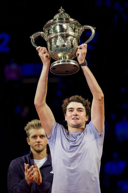 Brazil's Joao Fonseca raises the trophy after winning against Spain's Alejandro Davidovich Fokina in their men's final match at the Swiss Indoors ATP 500 tennis tournament in Basel on October 26, 2025. (Photo by Fabrice COFFRINI / AFP)