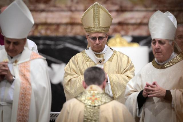 Archbishop Miroslaw Stanislaw Wachowski stands in front of Pope Leo XIV during a mass for his episcopal ordination at St Peter's basilica in The Vatican, on October 26, 2025. (Photo by Tiziana FABI / AFP)