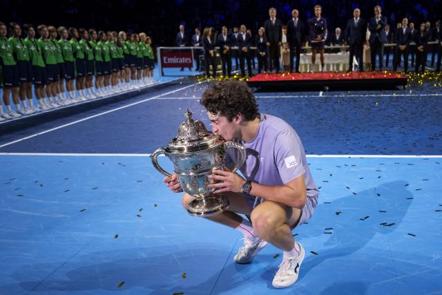 Brazil's Joao Fonseca kisses the trophy after winning against Spain's Alejandro Davidovich Fokina in their men's final match at the Swiss Indoors ATP 500 tennis tournament in Basel on October 26, 2025. (Photo by Fabrice COFFRINI / AFP)