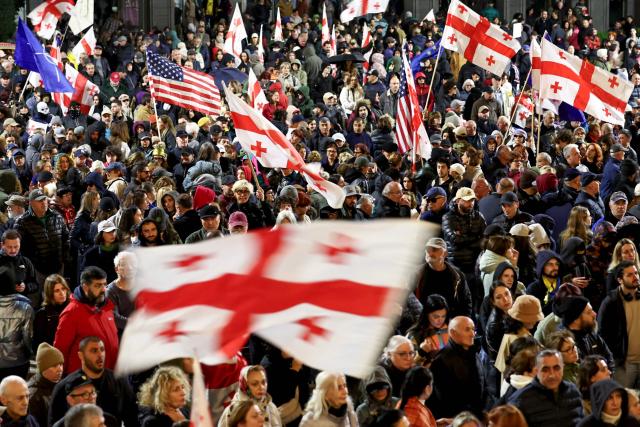 Demonstrators attend a rally marking the first anniversary of the disputed parliamentary elections in front of the parliament building in Tbilisi, on October 26, 2025. (Photo by Giorgi ARJEVANIDZE / AFP)