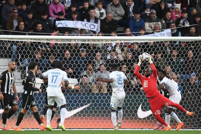 Angers' Burkinabe goalkeeper #12 Herve Koffi (2R) catches the ball during the French L1 football match between SCO Angers and FC Lorient at the Raymond-Kopa Stadium in Angers, western France, on October 26, 2025. (Photo by JEAN-FRANCOIS MONIER / AFP)