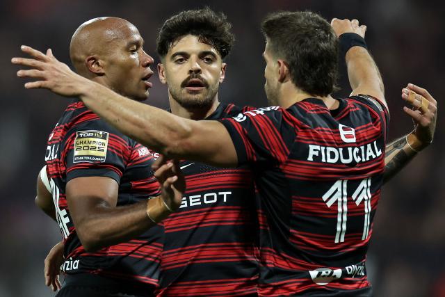 Toulouse's Argentinian wing Juan Cruz Mallia (R) celebrates with Toulouse's French wing Teddy Thomas (L) and Toulouse's French fly-half Romain Ntamack (C) after scoring Toulouse's first try during the French Top14 rugby union match between Stade Toulousain Rugby (Toulouse) and Rugby Club Toulonnais (Toulon) at the Ernest-Wallon stadium in Toulouse, south-western France, on October 26, 2025. (Photo by Valentine CHAPUIS / AFP)