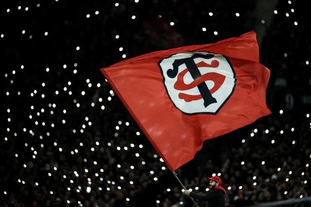 TOPSHOT - A Stade Toulouse supporter waves a giant flag from the stands during the French Top14 rugby union match between Stade Toulousain Rugby (Toulouse) and Rugby Club Toulonnais (Toulon) at the Ernest-Wallon stadium in Toulouse, south-western France, on October 26, 2025. (Photo by Valentine CHAPUIS / AFP)