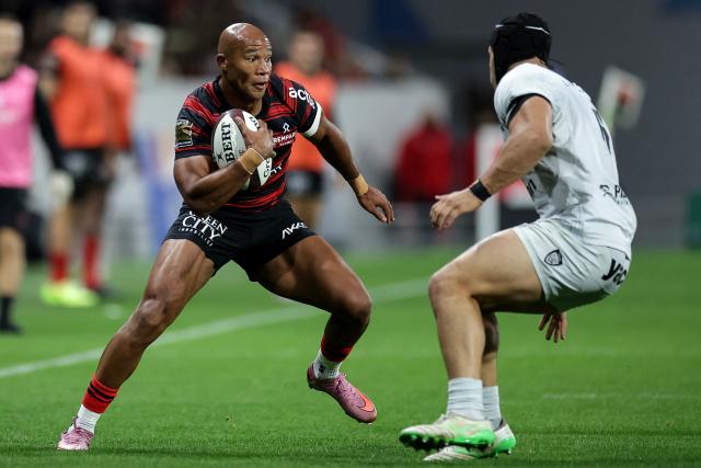 Toulouse's French wing Teddy Thomas (L) runs with the ball during the French Top14 rugby union match between Stade Toulousain Rugby (Toulouse) and Rugby Club Toulonnais (Toulon) at the Ernest-Wallon stadium in Toulouse, south-western France, on October 26, 2025. (Photo by Valentine CHAPUIS / AFP)