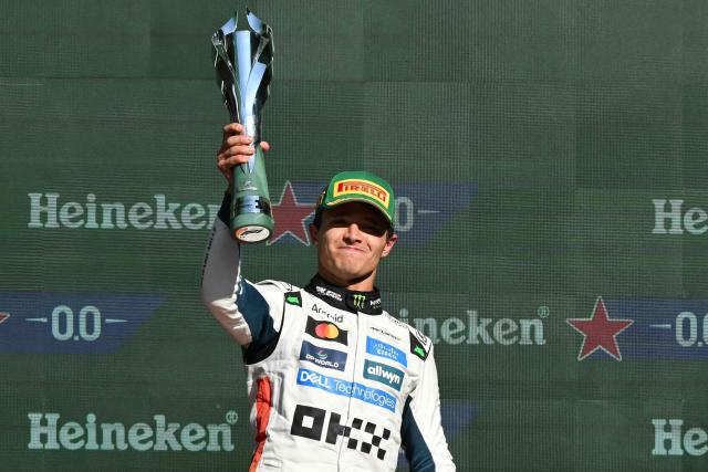 McLaren's British driver Lando Norris lifts the trophy on the podium after winning the Mexico City Formula One Grand Prix at the Hermanos Rodriguez racetrack in Mexico City on October 26, 2025. (Photo by Yuri CORTEZ / AFP)