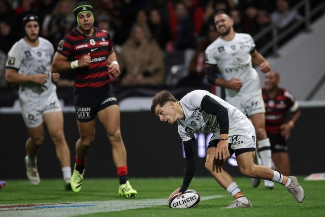 Toulon's French full-back Mathis Ferte (2R) grounds the ball to score a try during the French Top14 rugby union match between Stade Toulousain Rugby (Toulouse) and Rugby Club Toulonnais (Toulon) at the Ernest-Wallon stadium in Toulouse, south-western France, on October 26, 2025. (Photo by Valentine CHAPUIS / AFP)