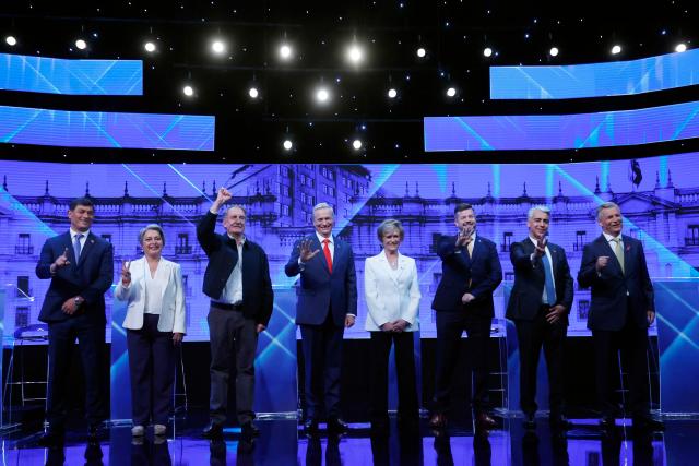 TOPSHOT - Presidential candidates (L-R) Franco Parisi for the 'Partido de la Gente' (People's Party), Jeannette Jara of the Progressive Center-Left Coalition 'Unidad por Chile,' Eduardo Artes of the Communist Party of the Proletarian Action Party, Jose Antonio Kast of the Republican party, Evelyn Matthei of the Chile Vamos coalition, Johannes Kaiser, of the Libertarian National party, Marco Enriquez-Ominami, from the Progresista Party and Harold Mayne-Nicholls, pose for a picture ahead of a debate organized by Channel 13 Television in Santiago on October 26, 2025. Chile will hold the presidential election on November 16, 2025. (Photo by Raul BRAVO / AFP)