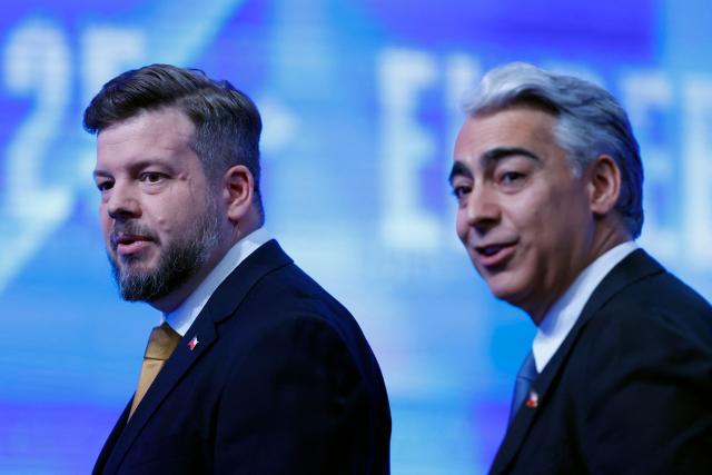 Presidential candidates Johannes Kaiser, of the Libertarian National party (L) and Marco Enriquez-Ominami of the Progresist Party, look on ahead of a debate organized by Channel 13 Television in Santiago on October 26, 2025. Chile will hold the presidential election on November 16, 2025. (Photo by Raul BRAVO / AFP)