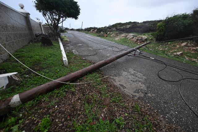 A fallen Jamaica Public Service Company light pole is seen on the Sugar Man's beach main road in Hellshire, St Catherine parish, near Portmore, as Jamaica starts to feel the effects of Hurricane Mellisa on October 26, 2025. Hurricane Melissa, already a major category 4 storm, gathered steam Sunday as it took aim at Jamaica and other parts of the Caribbean, with forecasters predicting catastrophic flooding and urging residents to seek shelter immediately. (Photo by Ricardo Makyn / AFP)