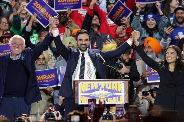 New York City mayoral candidate Zohran Mamdani (C) holds hands with US Senator Bernie Sanders (I-VT) (L) and US Representative Alexandria Ocasio-Cortez (D-NY) at the end of a campaign rally at Forest Hills Stadium in the Queens borough of New York City on October 26, 2025. New Yorkers will cast their votes for mayor on November 4, 2025. Mamdani, the Democratic candidate, is the current frontrunner ahead of former New York Governor and independent candidate Andrew Cuomo and Republican candidate Curtis Sliwa. (Photo by ANGELA WEISS / AFP)