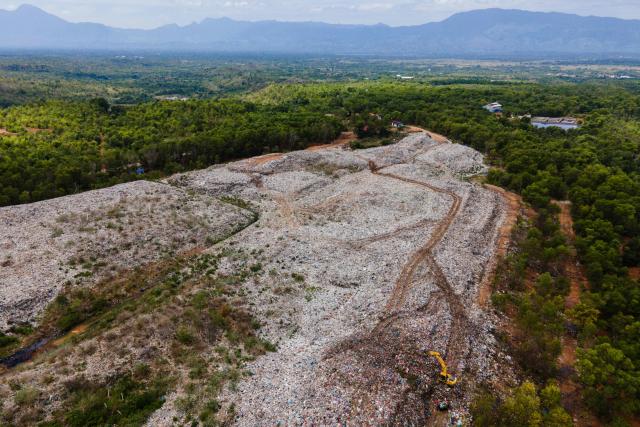 This aerial picture show an excavator being operated at a landfill near the Sultan Iskandar Muda international airport in Blang Bintang, Aceh province on October 27, 2025. (Photo by CHAIDEER MAHYUDDIN / AFP/Chaideer MAHYUDDIN / AFP)