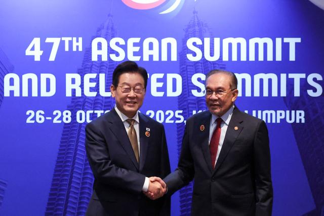 Malaysia's Prime Minister Anwar Ibrahim (R) shakes hands with South Korea's President Lee Jae Myung during a bilateral meeting on the sidelines of the 47th Association of Southeast Asian Nations (ASEAN) Summit in Kuala Lumpur on October 27, 2025. (Photo by Hasnoor Hussain / POOL / AFP)