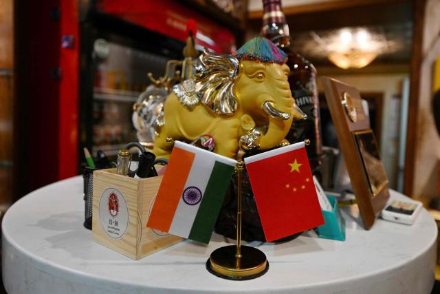 The national flags of India (L) and China are seen on display at an Indian restaurant in Beijing on October 27, 2025. (Photo by Adek BERRY / AFP)