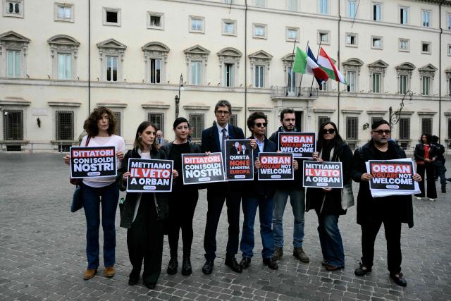 Riccardo Magi (4thL), secretary of Italian pro-Europe party +Europa (More Europe), stage a protest against Hungary's Prime Minister Viktor Orban in front of Palazzo Chigi prior a meeting with Italy's Prime Minister, Giorgia Meloni, in Rome on October 27, 2025. Placards read "Dictator with our money" "This is not our Europe" "Orban you are not welcome". (Photo by Tiziana FABI / AFP)