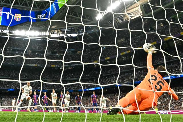 Barcelona's Polish goalkeeper #25 Wojciech Szczesny saves a shot from the penalty spot by Real Madrid's French forward #10 Kylian Mbappe during the Spanish league football match between Real Madrid CF and FC Barcelona at Santiago Bernabeu Stadium in Madrid on October 26 , 2025. (Photo by Javier SORIANO / AFP)