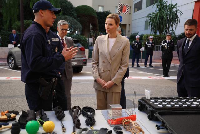 Princess Charlene of Monaco (C) and her brother Gareth Wittstock (R) attend the presentation ot the canine brigade in The Principality of Monaco on October 27, 2025. (Photo by Valery HACHE / AFP) / / NO TABLOIDS WEB & PRINT, NO DAILY MAIL, NO DAILY MAIL GROUP, NO VOICI, NO CLOSER