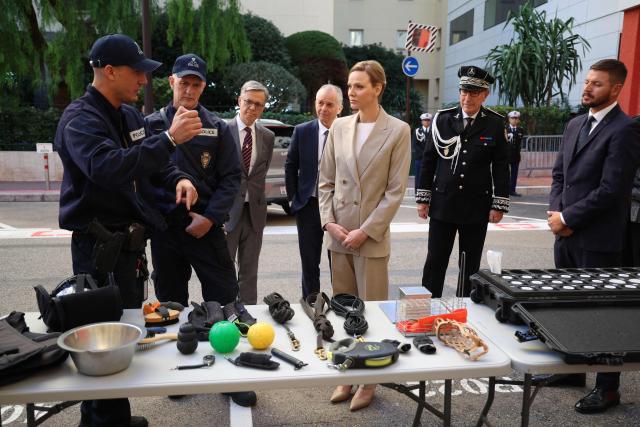 Princess Charlene of Monaco (C) and her brother Gareth Wittstock (R) attend the presentation ot the canine brigade in The Principality of Monaco on October 27, 2025. (Photo by Valery HACHE / AFP) / / NO TABLOIDS WEB & PRINT, NO DAILY MAIL, NO DAILY MAIL GROUP, NO VOICI, NO CLOSER