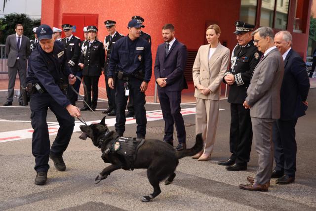 Princess Charlene of Monaco (4R) and her brother Gareth Wittstock (5R) attend the presentation ot the canine brigade in The Principality of Monaco on October 27, 2025. (Photo by Valery HACHE / AFP) / / NO TABLOIDS WEB & PRINT, NO DAILY MAIL, NO DAILY MAIL GROUP, NO VOICI, NO CLOSER