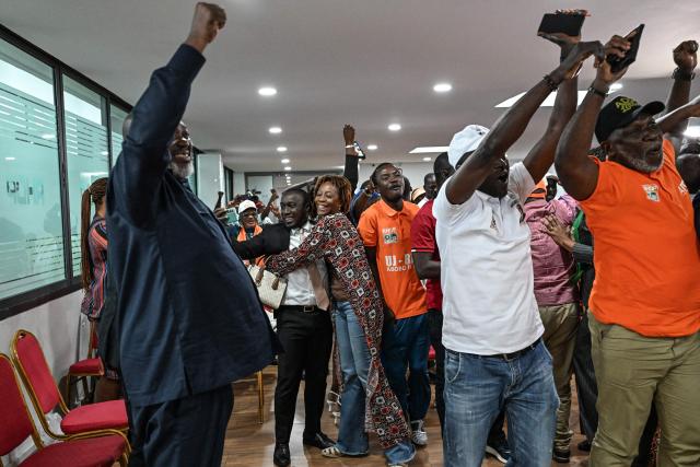 Supporters of Ivory Coast's President and presidential candidate for the Rally of Houphouetists for Democracy and Peace (RHDP) party Alassane Ouattara celebrate winning the presidential election at the party headquarters in Abidjan on October 27, 2025. Ivory Coast's President Alassane Ouattara has won a fourth term, securing a crushing 89.77 percent in a vote which his two greatest rivals were barred from, the electoral commission said on October 27, 2025. Nearly nine million voters were eligible to cast their ballot Saturday in the world's top cocoa producer, which has resisted coups and jihadist attacks plaguing much of west Africa but which saw tensions soar and deadly violence in the run-up to the election. (Photo by Sia KAMBOU / AFP)