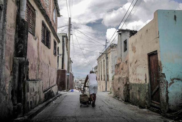 A man pulls a wheelbarrow loaded with water along a street in Santiago de Cuba, Cuba, on October 27, 2025, ahead of the arrival of Hurricane Melissa. Hurricane Melissa strengthened Monday as it took aim at Jamaica and other parts of the Caribbean as a top-level Category 5 storm, with forecasters predicting catastrophic flooding and urging residents to seek shelter immediately. After passing over Jamaica, the storm was forecast to head north and cross over eastern Cuba on Tuesday night, while continuing to bring rain and heavy winds to Haiti and the Dominican Republic. (Photo by AFP)