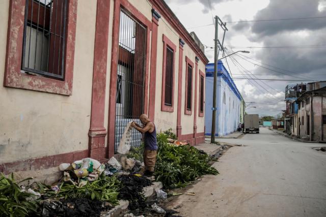 A man disposes of waste at a collection point ahead of the arrival of Hurricane Melissa in Santiago de Cuba, Cuba, on October 27, 2025. Hurricane Melissa strengthened Monday as it took aim at Jamaica and other parts of the Caribbean as a top-level Category 5 storm, with forecasters predicting catastrophic flooding and urging residents to seek shelter immediately. After passing over Jamaica, the storm was forecast to head north and cross over eastern Cuba on Tuesday night, while continuing to bring rain and heavy winds to Haiti and the Dominican Republic. (Photo by AFP)