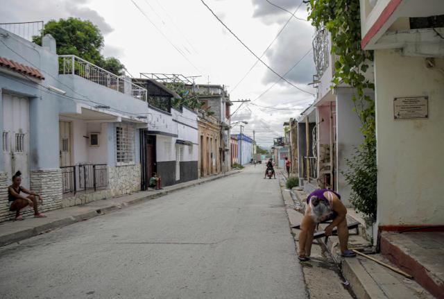A woman cleans in front of her house ahead of the arrival of Hurricane Melissa in Santiago de Cuba, Cuba, on October 27, 2025. Hurricane Melissa strengthened Monday as it took aim at Jamaica and other parts of the Caribbean as a top-level Category 5 storm, with forecasters predicting catastrophic flooding and urging residents to seek shelter immediately. After passing over Jamaica, the storm was forecast to head north and cross over eastern Cuba on Tuesday night, while continuing to bring rain and heavy winds to Haiti and the Dominican Republic. (Photo by AFP)