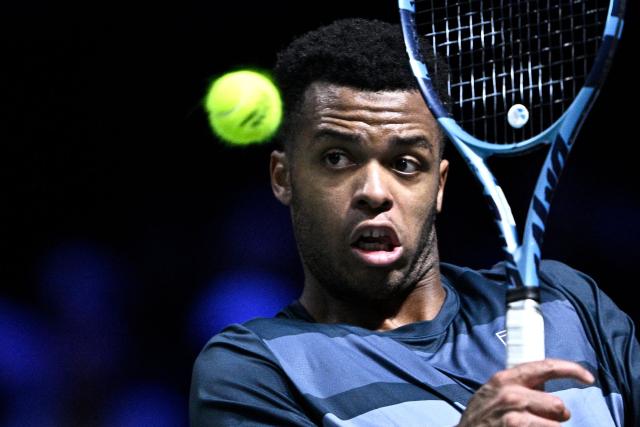 France's Giovanni Mpetshi Perricard plays a backhand return to Bulgaria's Grigor Dimitrov during their men's singles match on day one of the Paris ATP Masters 1000 tennis tournament at the Paris La Défense Arena in Nanterre, on the outskirts of Paris, on October 27, 2025. (Photo by JULIEN DE ROSA / AFP)